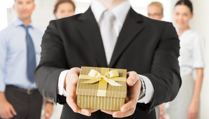 man hands holding gift box in office close up of man hands holding gift box in office